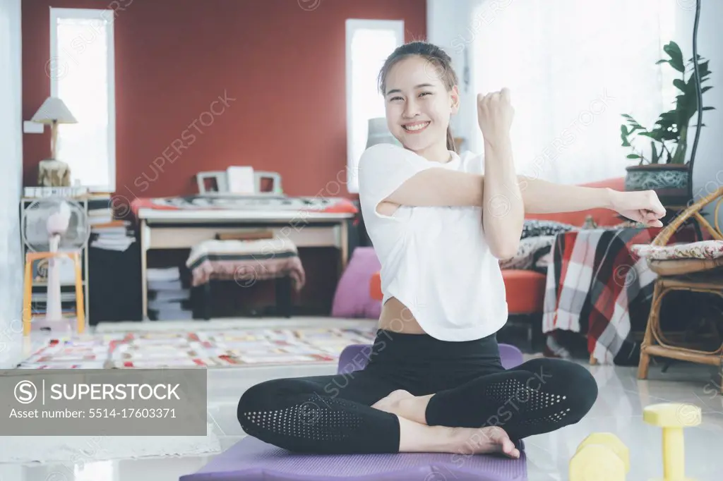 Athletic woman doing fitness stretching exercises at home