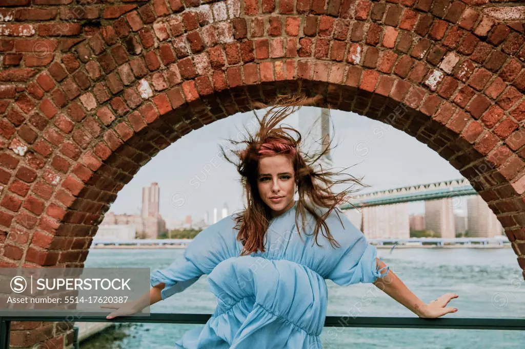 Portrait of young woman standing in windy weather.
