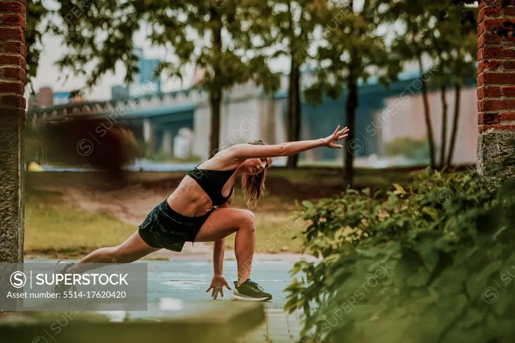 Young woman exercising outdoors in park.