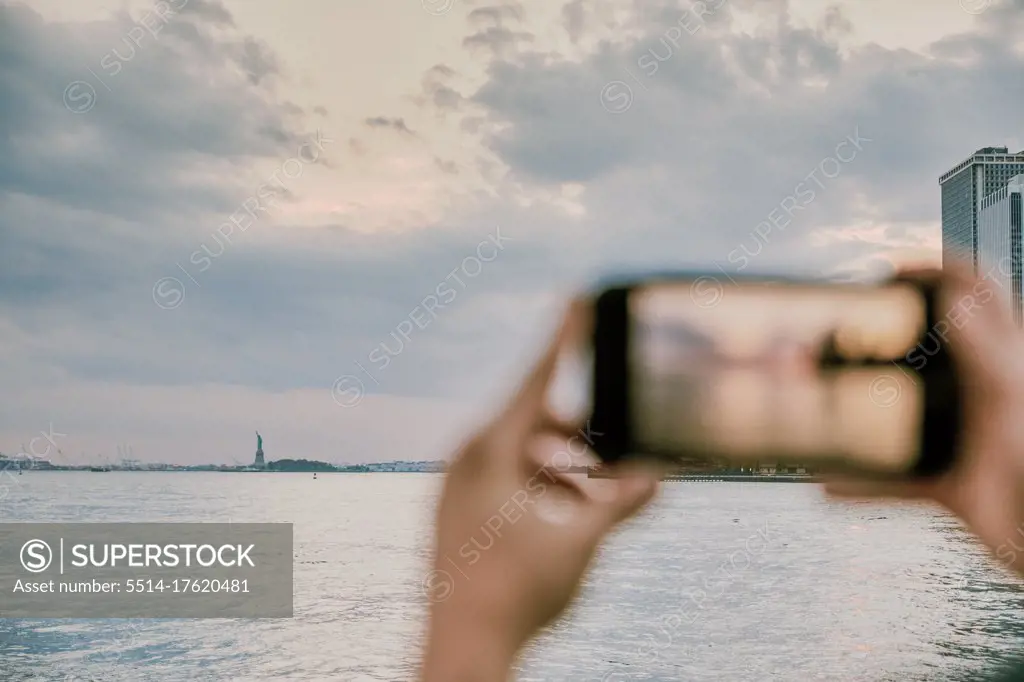 Phone taking picture of new york city skyline at sunset.