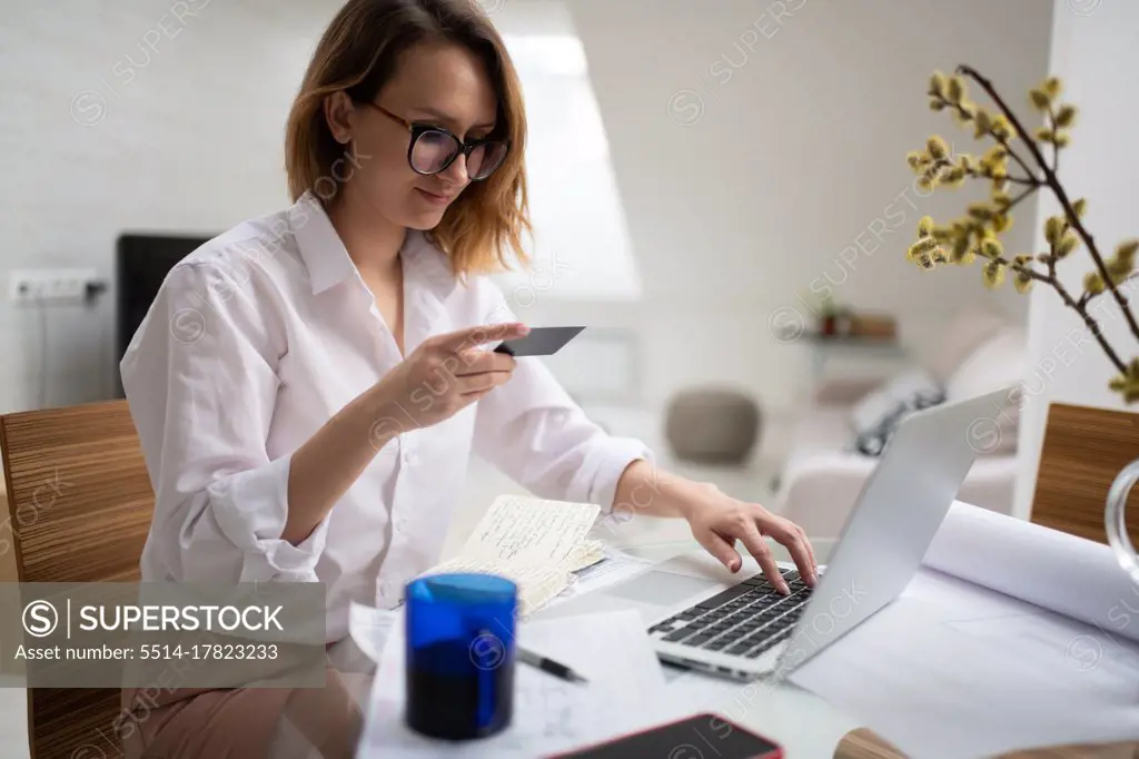 Busy woman doing online purchase on laptop