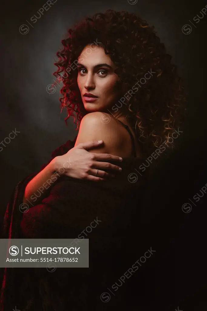 Awesome beautiful Girl with afro hair. Black background and red light.