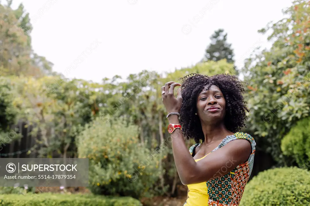 Portrait of confident happy afro hair woman at greenary