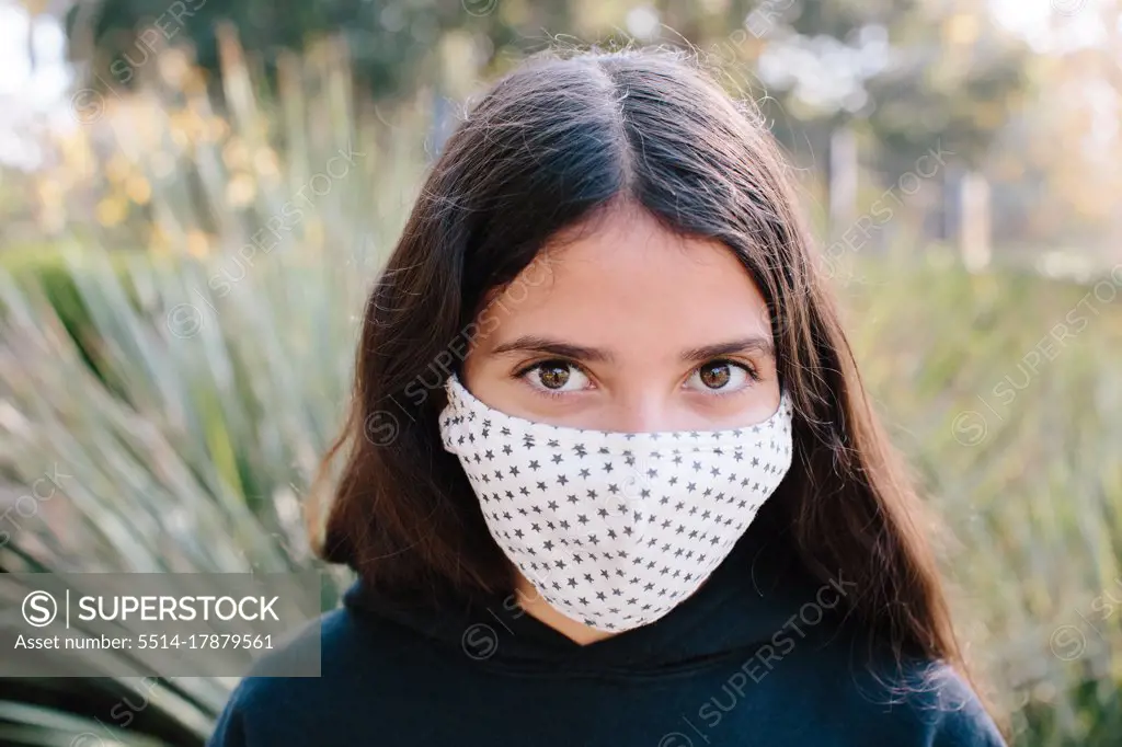 Tween Girl Looking At Camera While Wearing A Cloth Face Mask