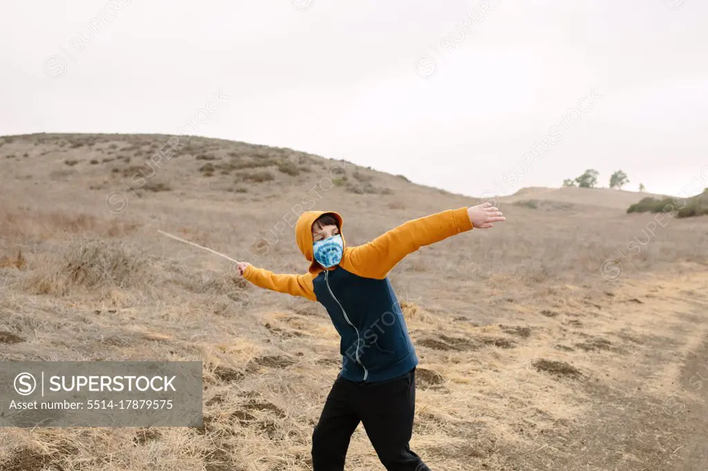 Boy On A Trail Wearing A Cloth Face Mask Gets Ready To Throw A stick