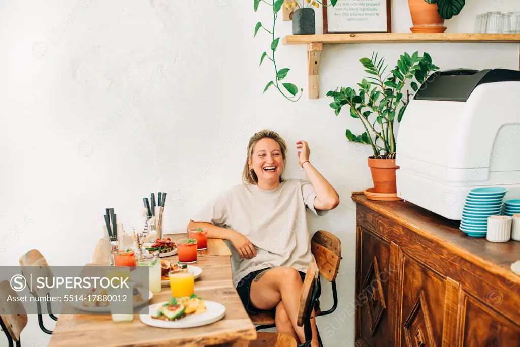 Young woman laughing while sitting in cafe