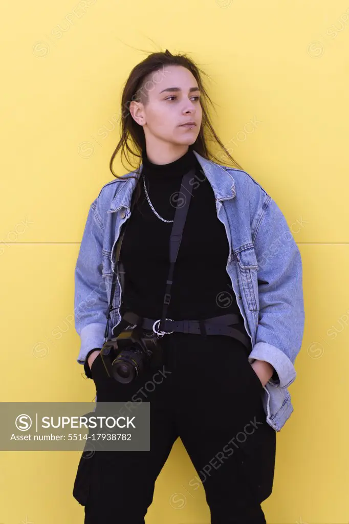 Young girl dressed in modern clothes pictured with her photo cam