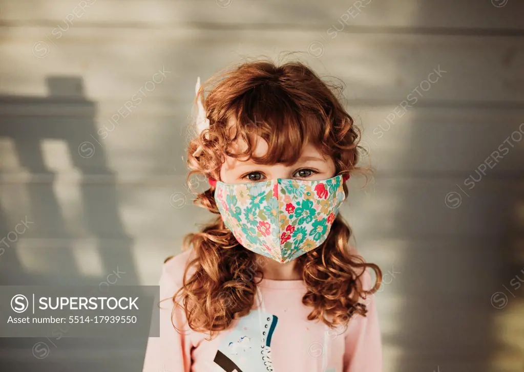 Young girl looking wearing floral homemade face mask outside