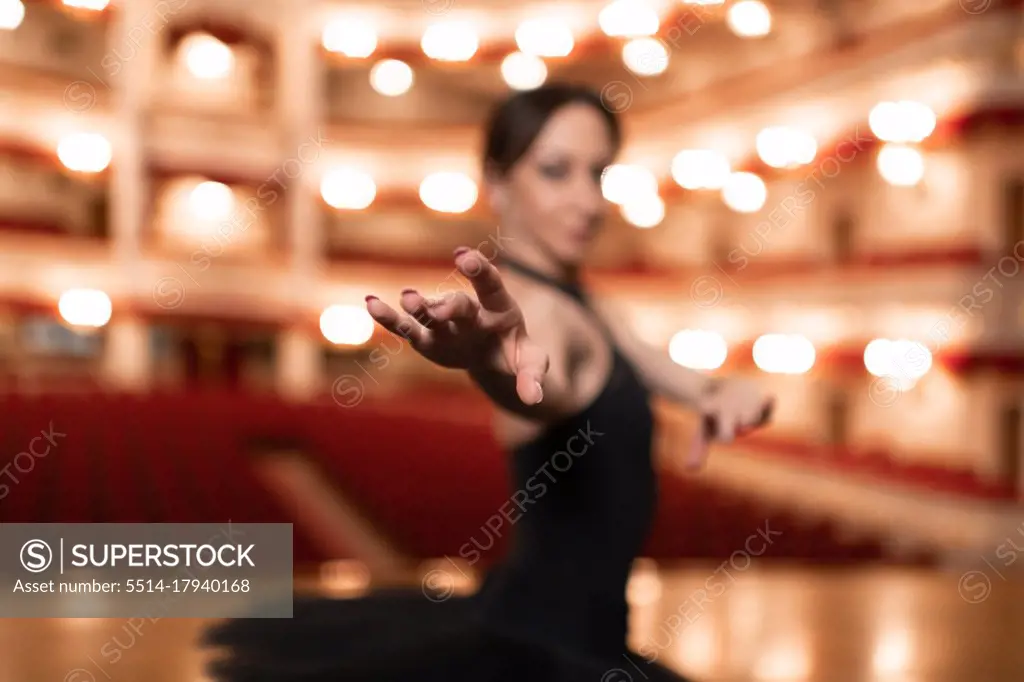 Graceful ballerina dancing in empty theater
