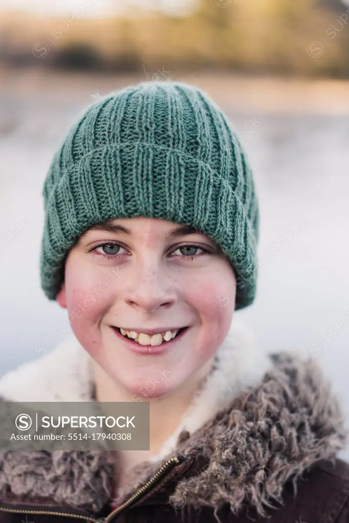 winter portrait of smiling 10 year old boy with a woolly hat