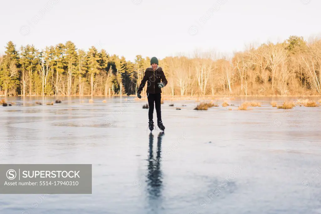 boy skating on a frozen open pond in New-England