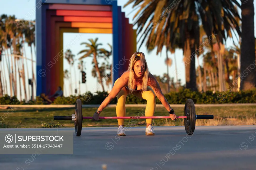 Girl working out lifting weights sunrise in santa barbara california