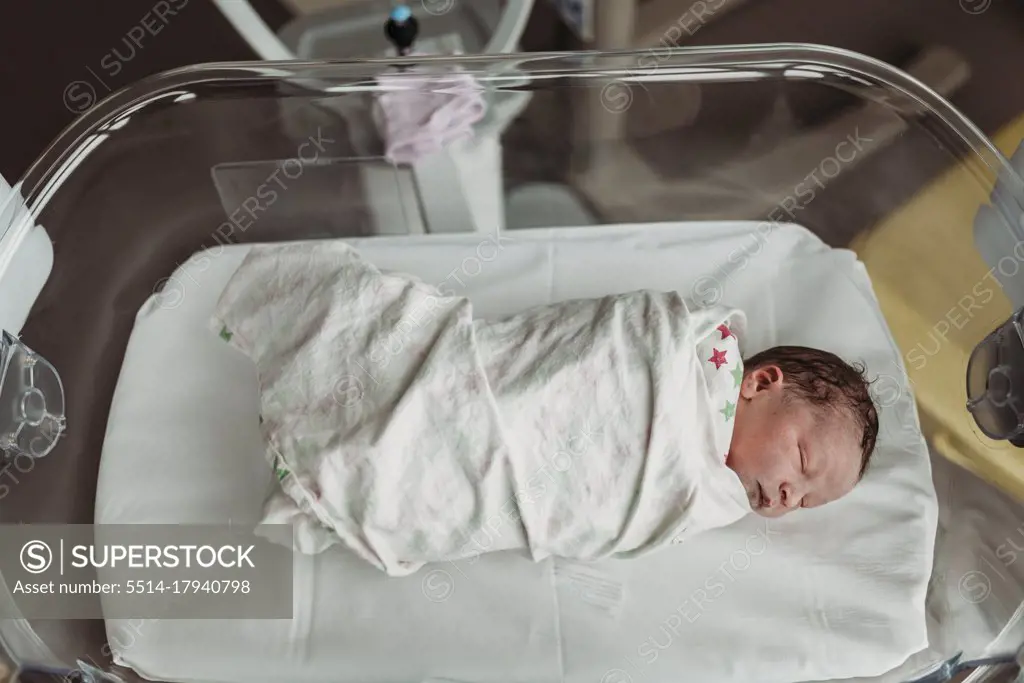 Above angle view of newborn baby boy right after birth in bassinet