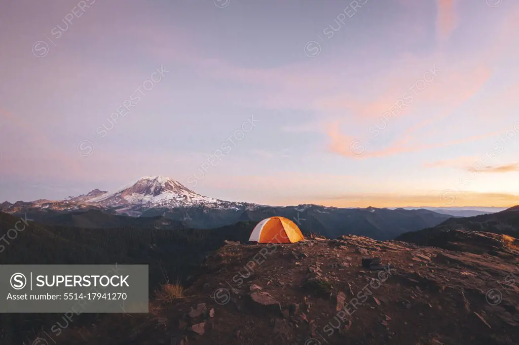 Orange tent on the top of the mountain near mt. Rainier
