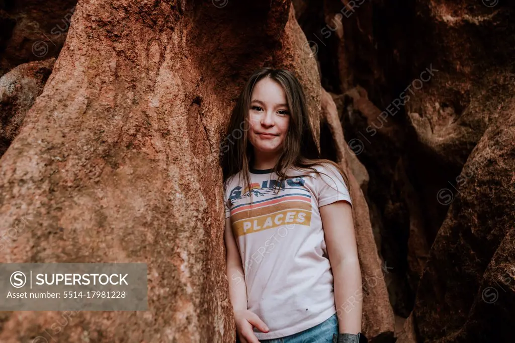 Happy Preteen girl hiking on rocks on a warm day