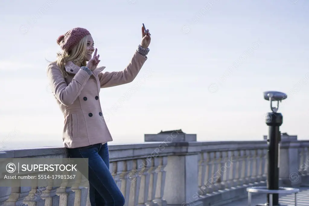 Female solo traveler using smartphone to take a selfie