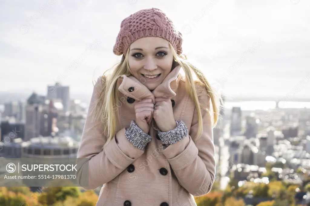 Blonde woman with pink coat showing its cold outside