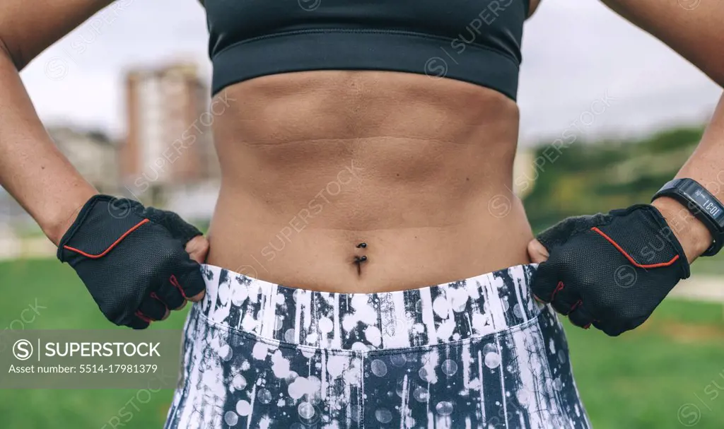 Female athlete posing showing abdominal muscles