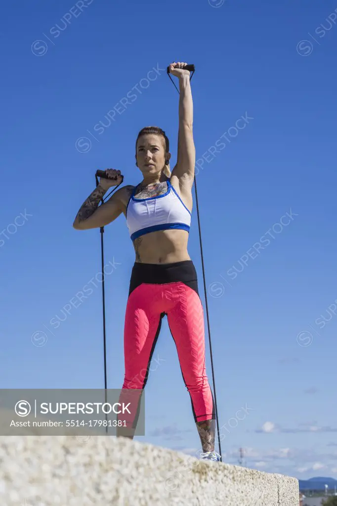 Young female athlete using elastic bands while working out