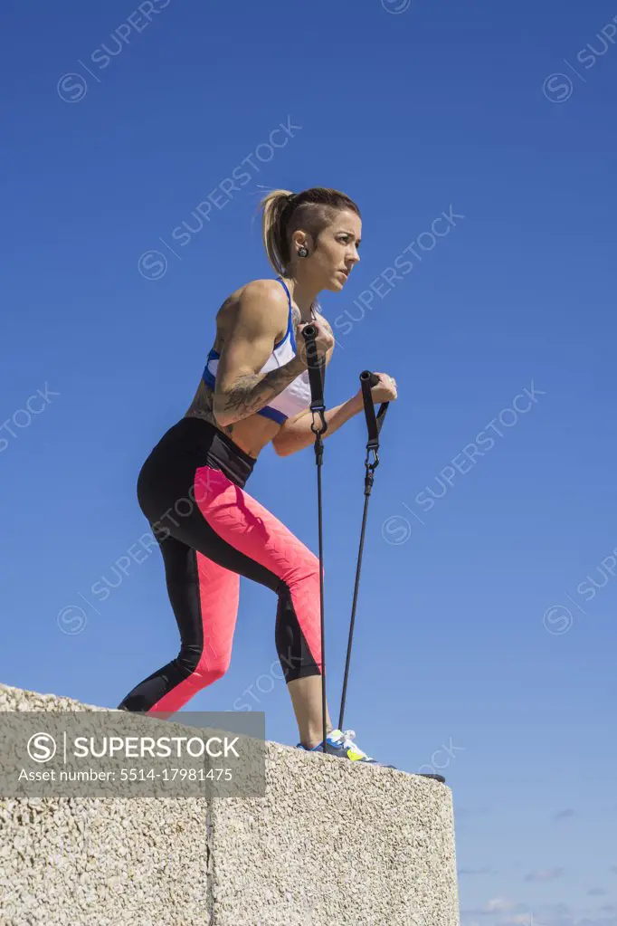 Female athlete using elastic bands while working out