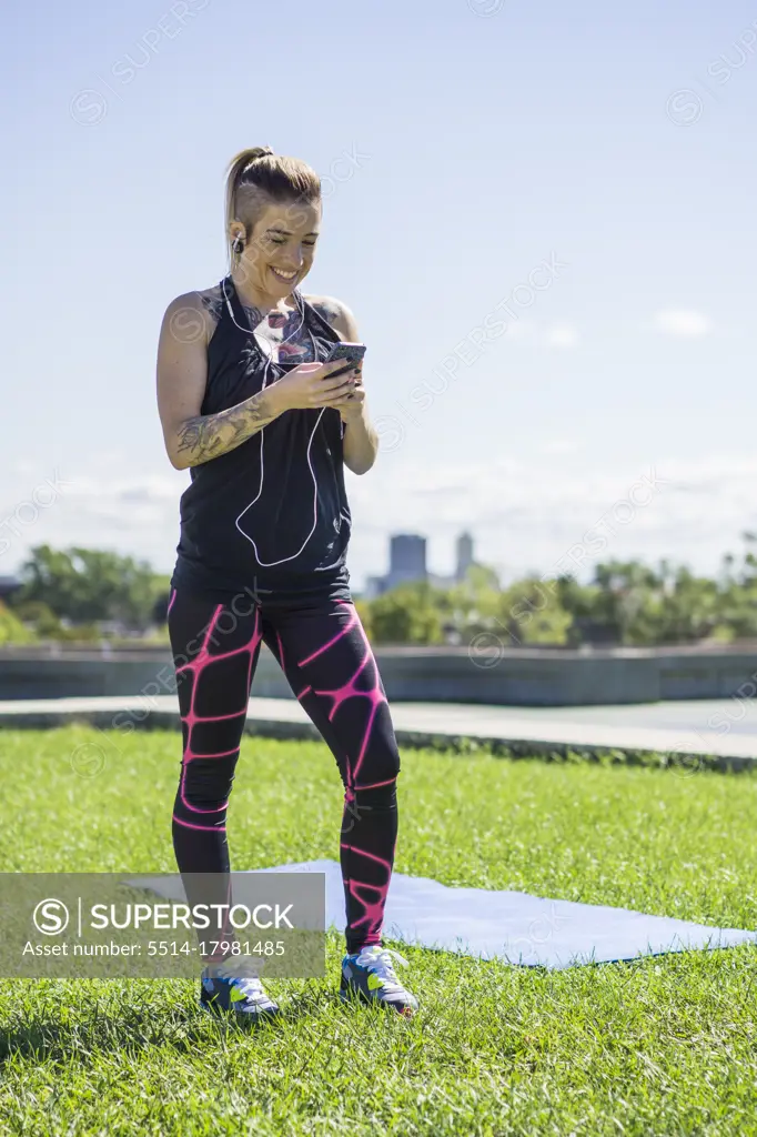 Young athletic female using smartphone while working out