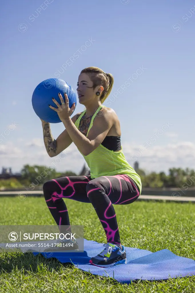 Young female athlete working out with medicine ball