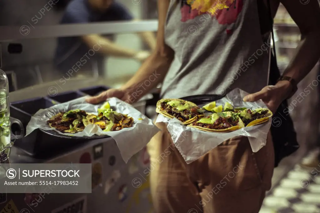 Healthy Mexican taco street food held by strong healthy tourist