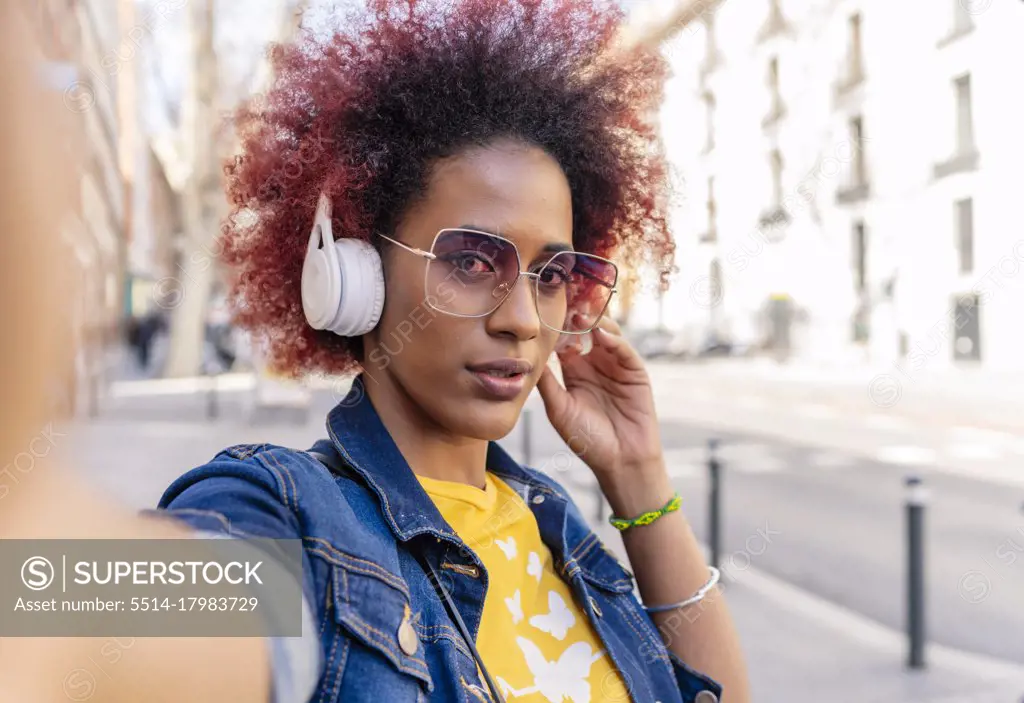selfie of woman with afro hair with her headphones