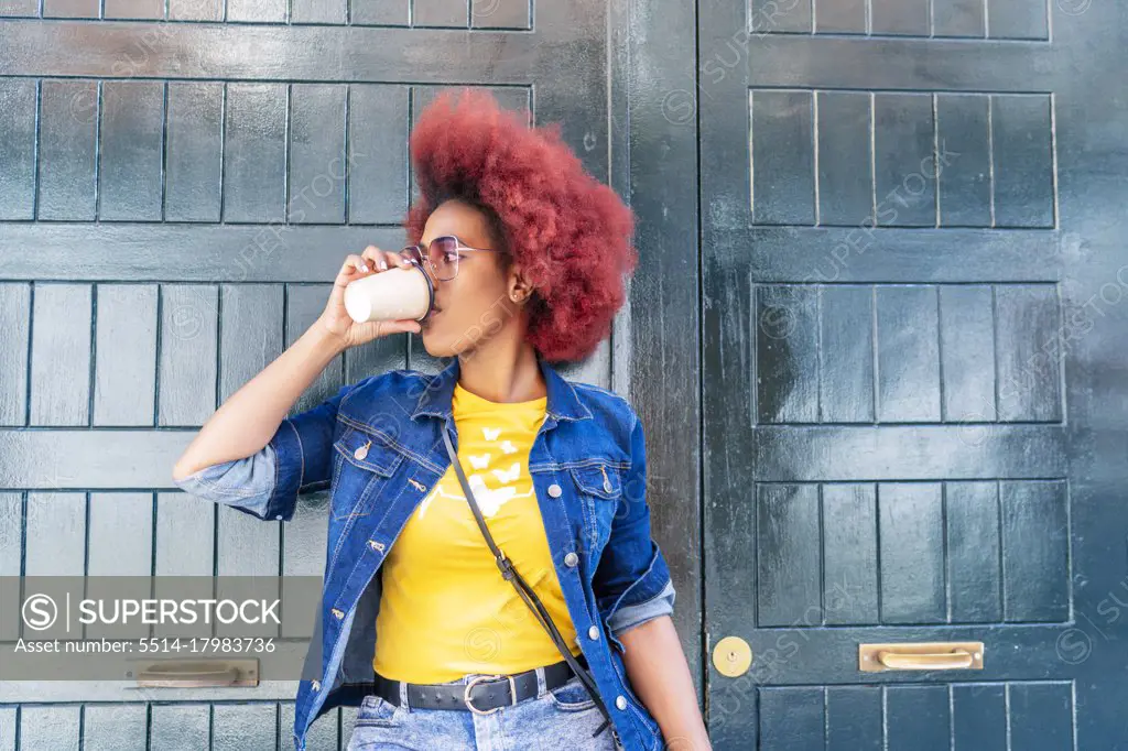 woman with red afro hair having a cup of coffee