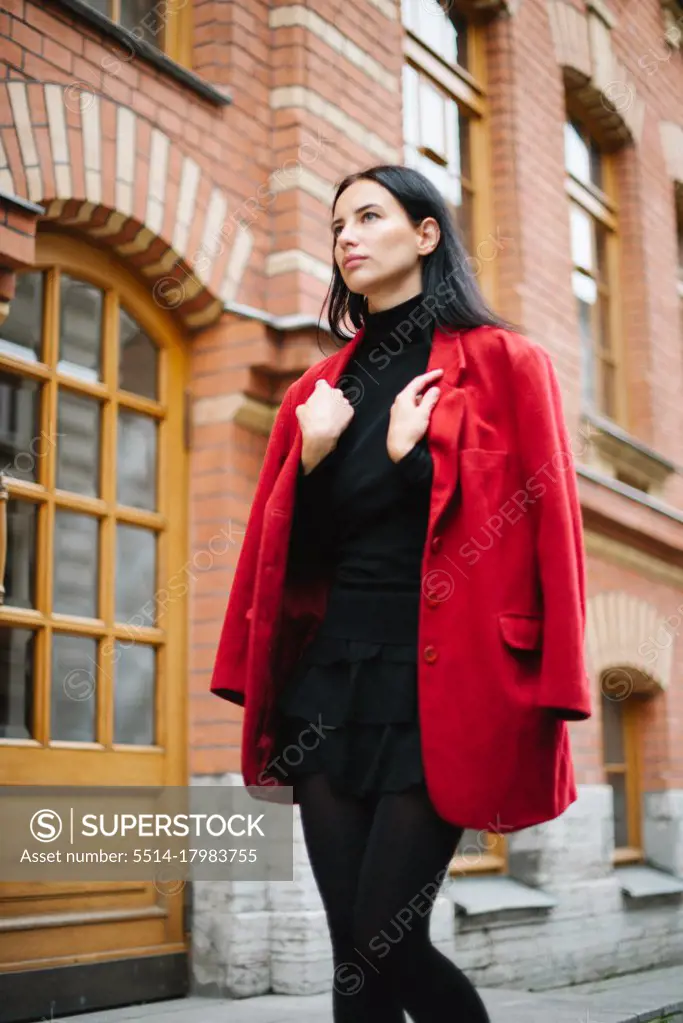 Young style fashion woman in red jacket in city