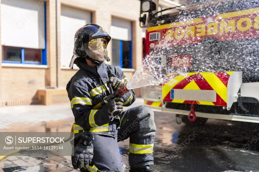 firefighter pouring water to extinguish a fire