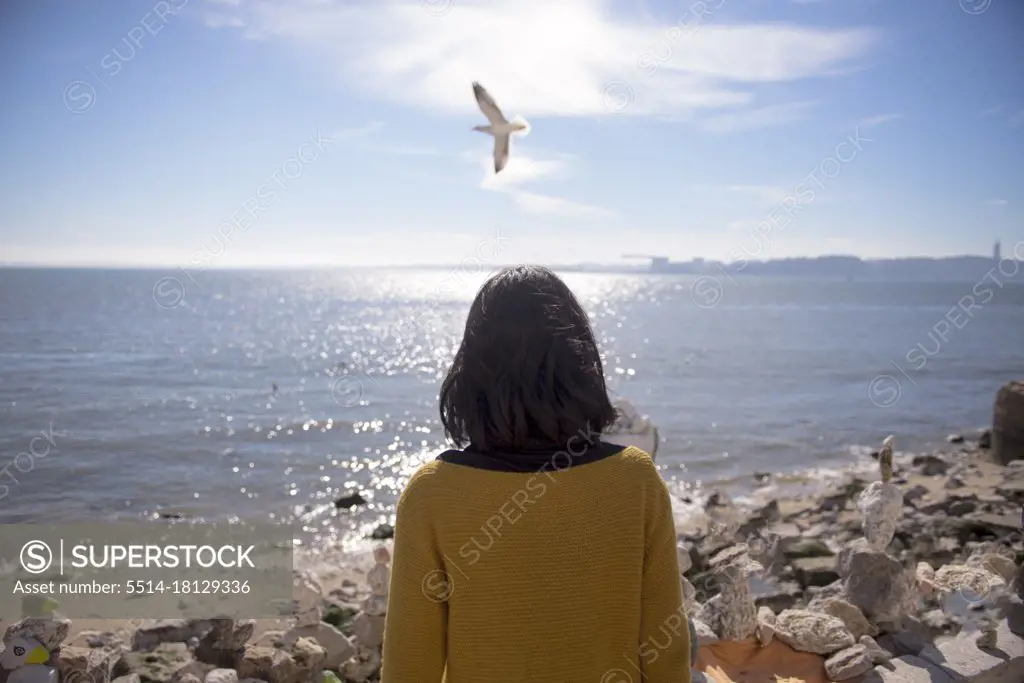 lonely girl on the bank of the river, stands with her back