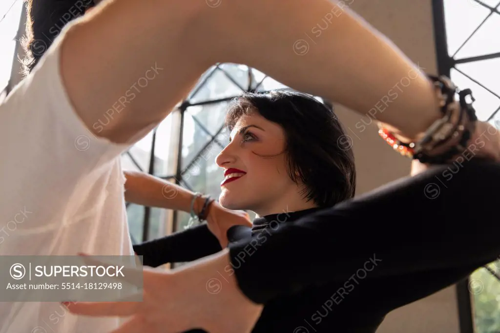 Cheerful woman practicing ballroom dance with partner