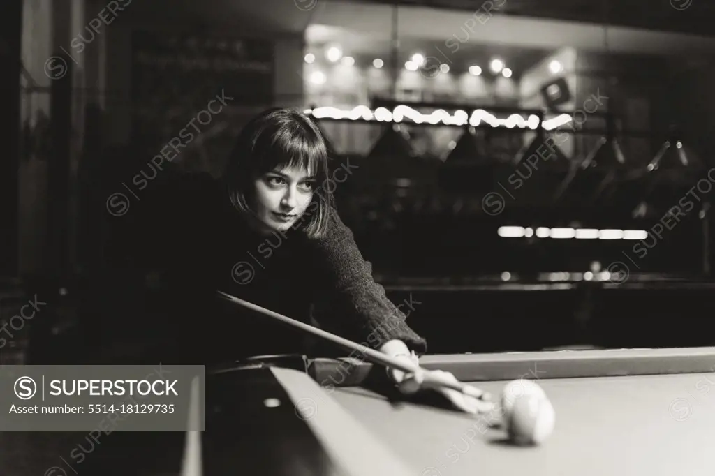 Woman with short hair playing billiards