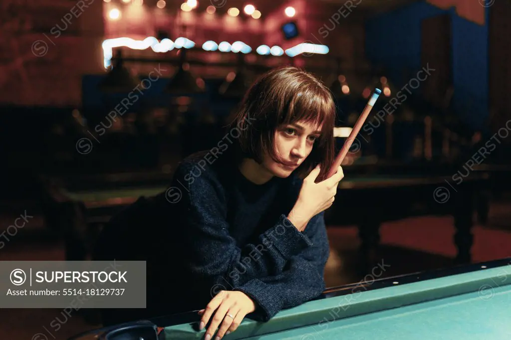 Young Girl Playing Pool In A Bar