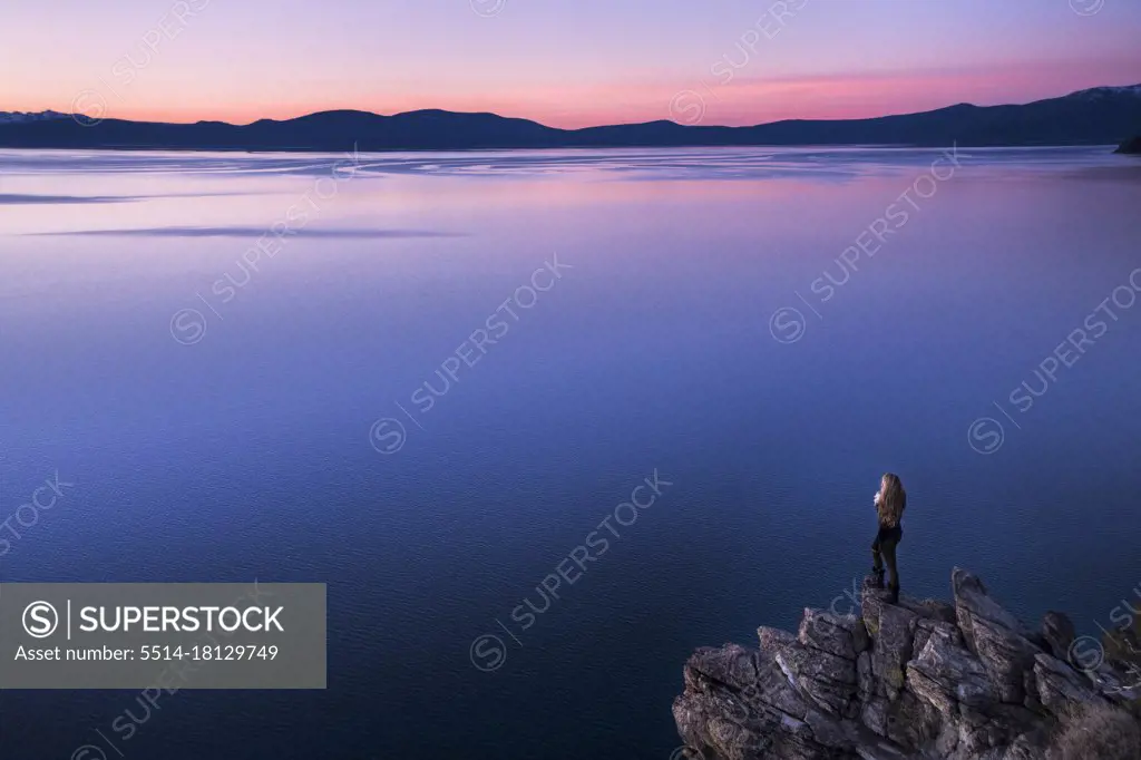 young female overlooking lake tahoe at sunset