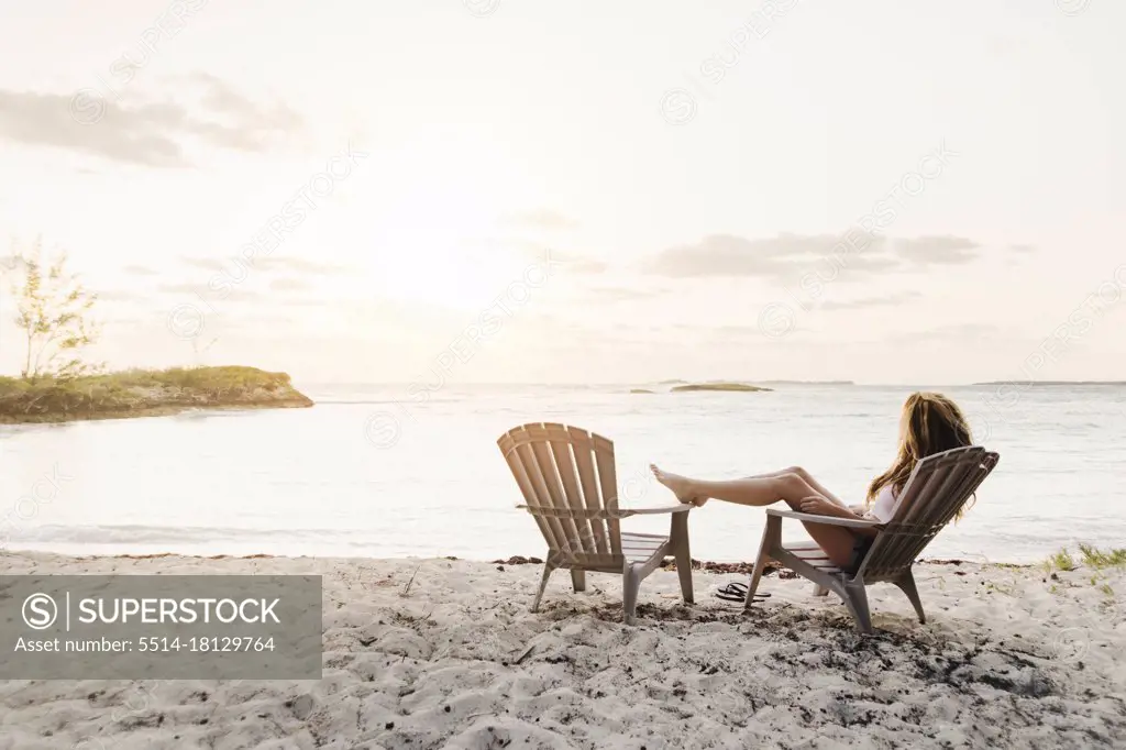 young female sitting on beach at sunset in Bahamas