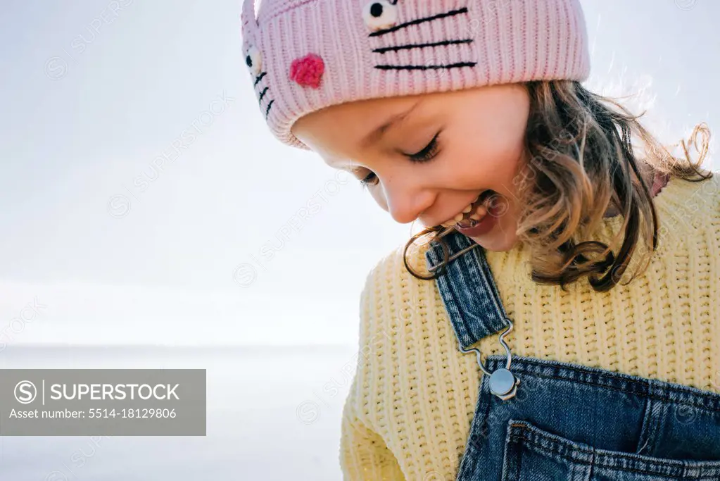 candid portrait of a child laughing at the beach in the sunshine in UK