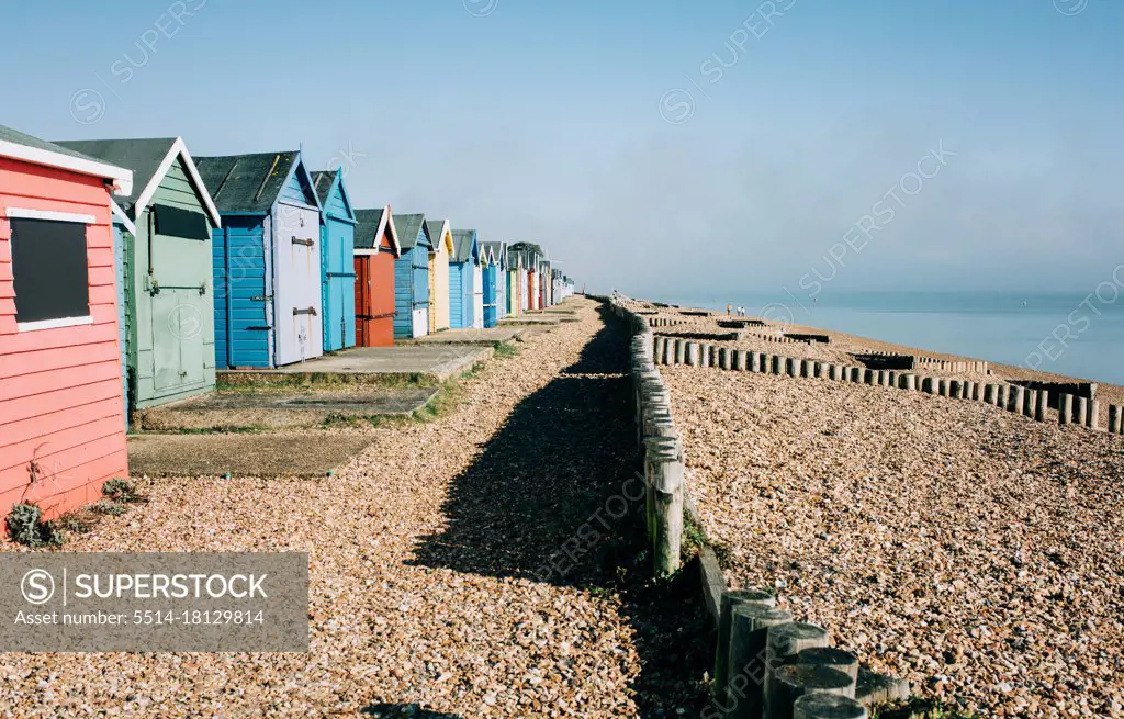 colourful huts on a pebble beach on a sunny day in England