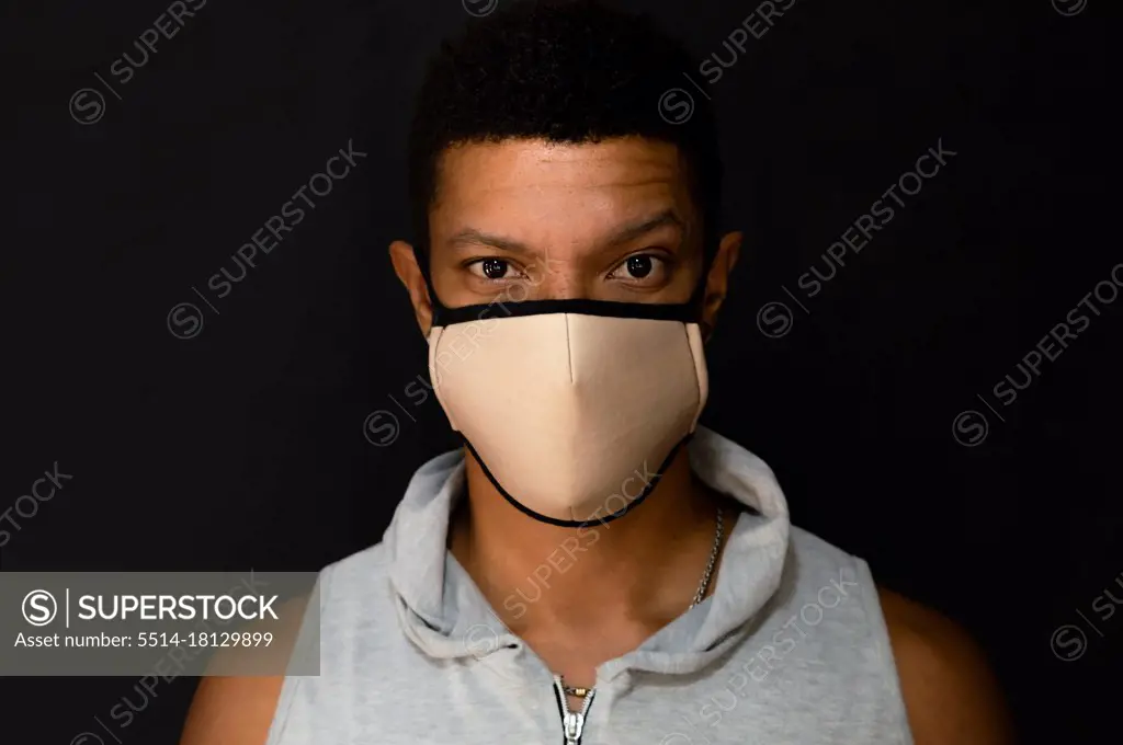 Young latin man with face mask and defiant look