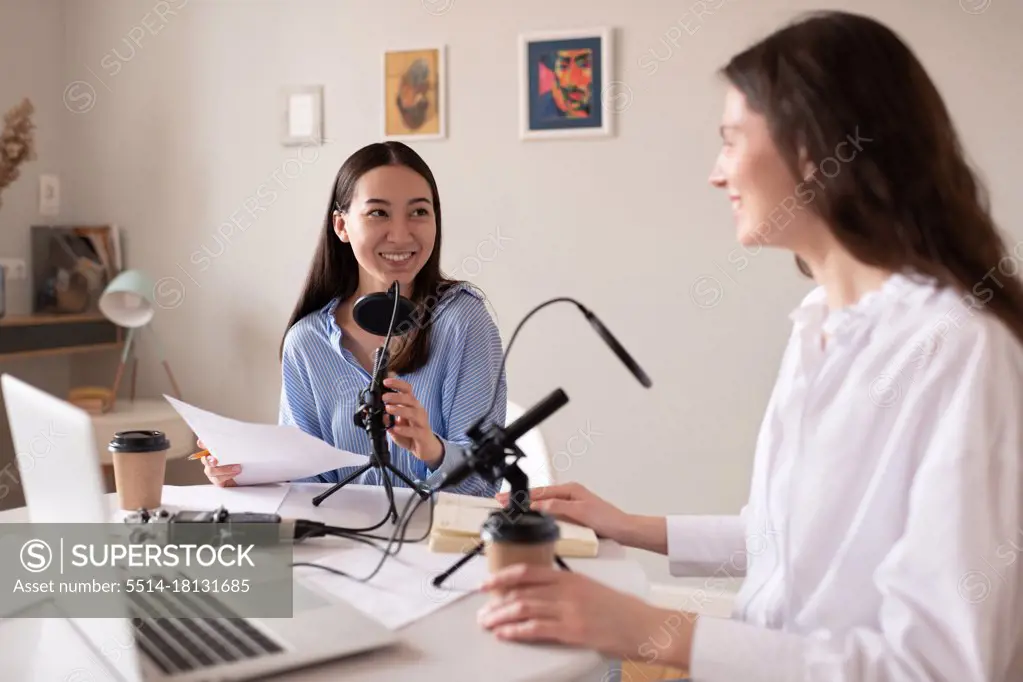 Multiracial women recording podcast in studio
