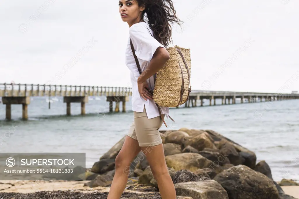 Young Woman exploring a rocky beach on overcast day