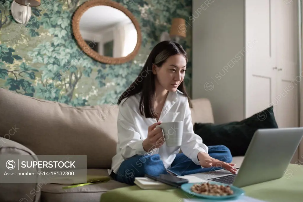 Asian woman preparing for online meeting at home