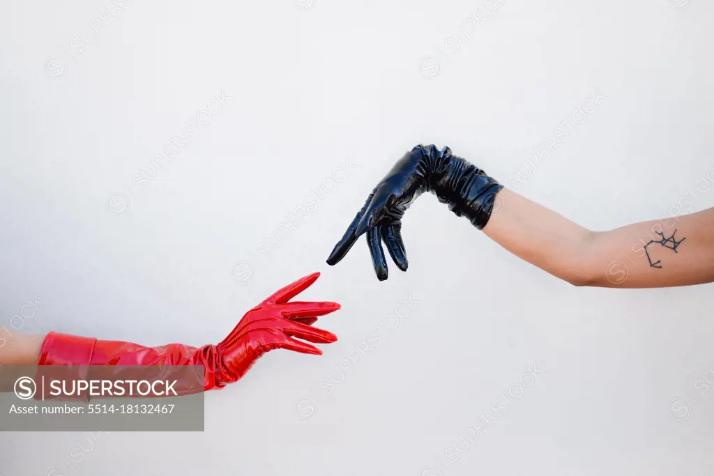 two hands wearing leather gloves about to touch