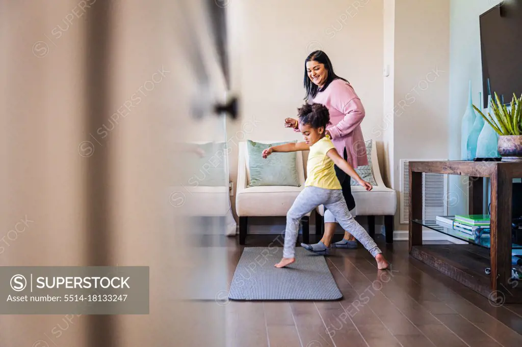 Girl practicing dance with smiling grandmother at home
