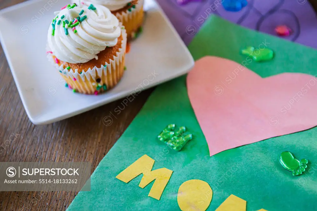 Close-up of cupcake by greeting card on table at home
