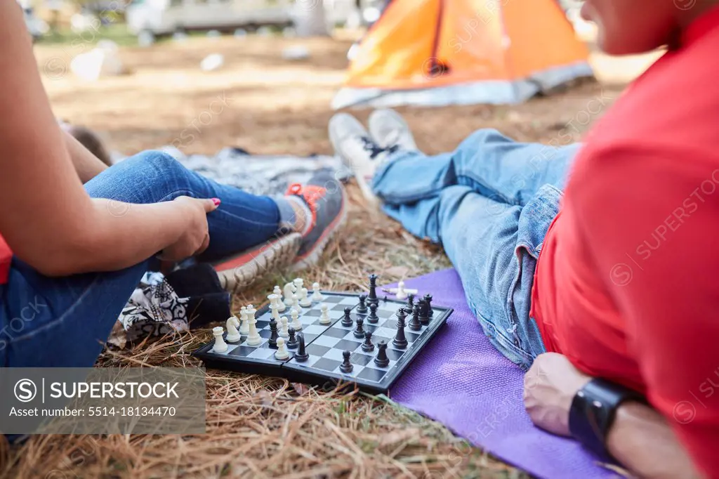 couple of friends playing chess outside their tent