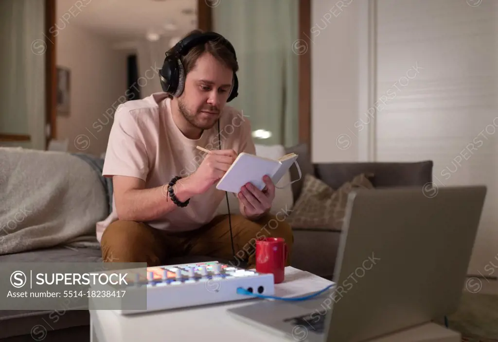 Male composer making notes in notepad