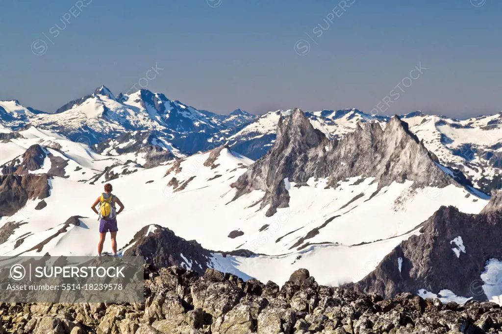 Fit attractive strong and active female backpacker on mountain summit