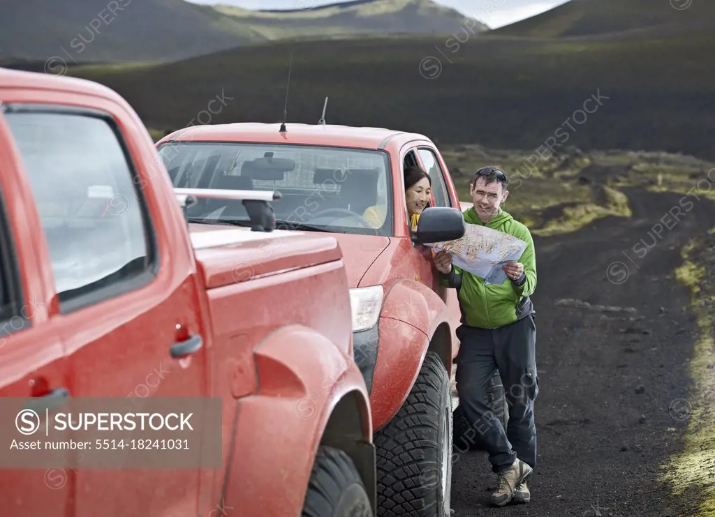 couple looking at map on road trip through the Icelandic highlands